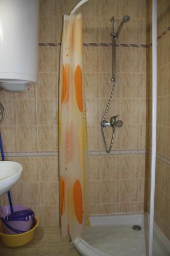 a shower with an orange shower curtain in a bathroom at Studio Moni in Pamporovo