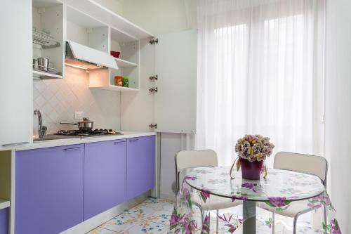 a kitchen with a table with a vase of flowers on it at Settessenze Residence & Rooms in Agropoli