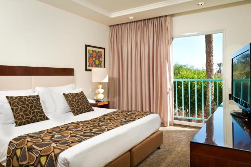 a hotel room with a bed and a balcony at Yam Suf by Isrotel Collection in Eilat