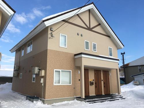 a brick house with snow on the ground at Wonderland Furano Pine in Furano