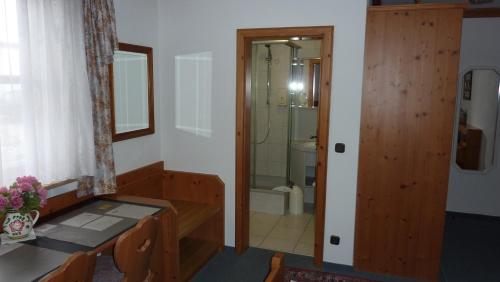 a bathroom with a table and a glass shower door at Hotel Hubertus in Kissing