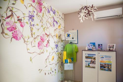 a room with a wall with flowers on it at Settessenze Residence & Rooms in Agropoli