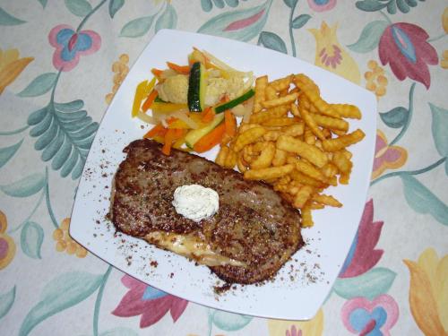 a plate of food with steak and french fries at Gasthof-Hotel Goldenes Schiff in Engelhartszell