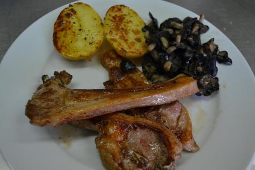 a white plate of food with meat and potatoes at Masia Molí de Tartareu in Tartareu