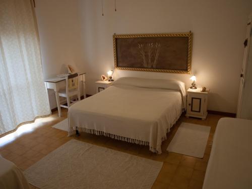 una camera da letto con un letto e un grande dipinto sul muro di Stella di Mare a La Maddalena