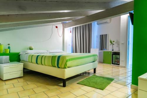 a bedroom with a large bed with green walls at Settessenze Residence & Rooms in Agropoli