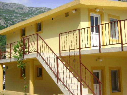 a yellow house with stairs on the side of it at Apartmani Grozdanic Canj in Čanj