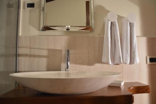 a bathroom with a white sink and a mirror at Fattoria Lucciano in Borghetto