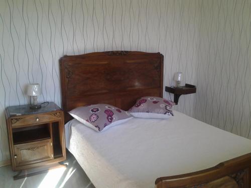 uma cama com duas almofadas com duas mesas de cabeceira em Gite de victor em Gigny-sur-Suran