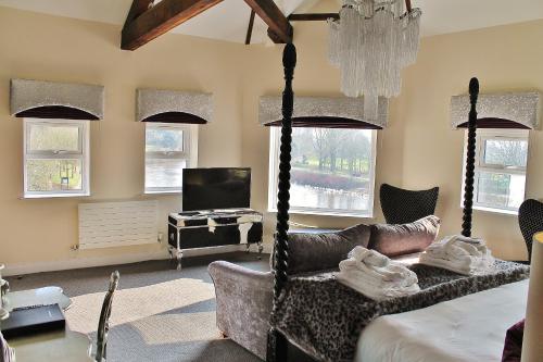 a bedroom with a bed and a tv and windows at Boutique By Browns in Worcester