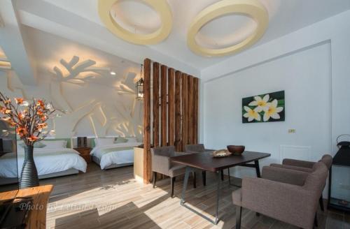 un soggiorno con un tavolo e una camera da letto di Mou Xia Villa a Wujie