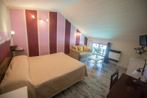 a hotel room with a bed and a couch at Cuccaro Club - Val di Vara e Cinque Terre in Rocchetta di Vara