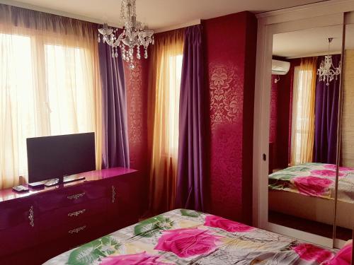 a bedroom with a bed and a tv and a mirror at Studios Zornitsa Burgas in Burgas