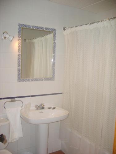 a white bathroom with a sink and a mirror at Hotel Hispanidad in Guadalupe