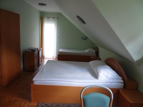 ツェリェにあるRooms Hochkrautのベッドルーム1室(ベッド1台、屋根裏部屋の椅子付)