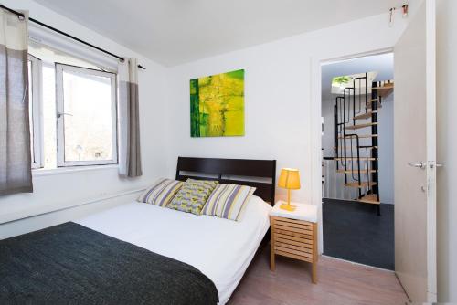 ロンドンにあるCamden Flatのベッドルーム(白いベッド1台、窓付)
