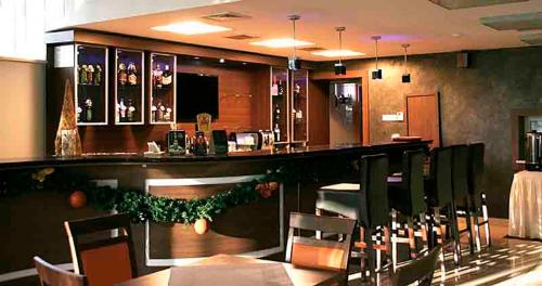a bar in a restaurant with tables and chairs at Hotel Ameliówka in Masłów