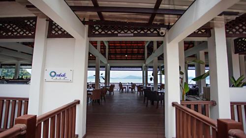 a restaurant with tables and chairs on a balcony at Casuarina Pangkor in Pangkor
