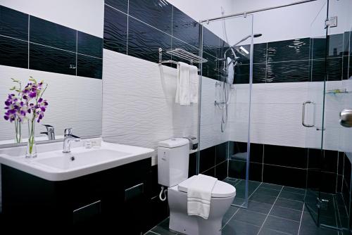 a bathroom with a toilet and a sink and a shower at Casuarina Pangkor in Pangkor