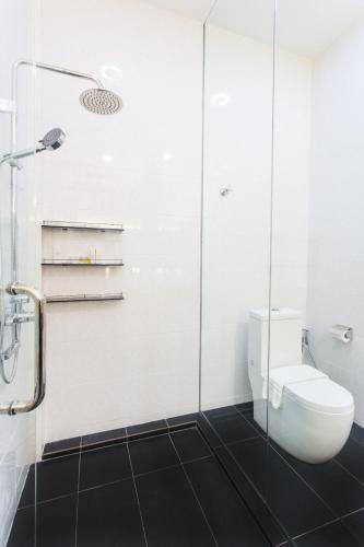a bathroom with a toilet and a glass shower at Casuarina Pangkor in Pangkor
