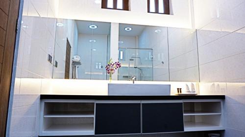 uma casa de banho com um lavatório e um espelho grande em Casuarina Pangkor em Pangkor