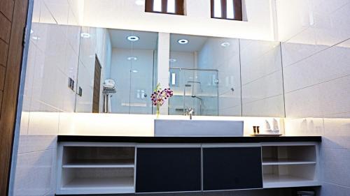 a bathroom with a sink and a large mirror at Casuarina Pangkor in Pangkor