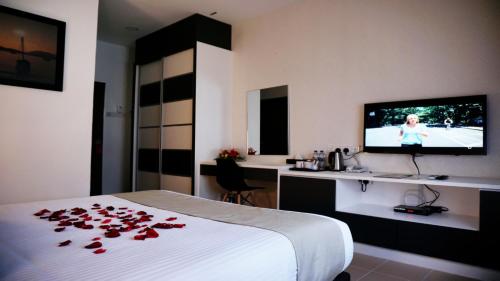 a hotel room with a bed with roses on it at Casuarina Pangkor in Pangkor
