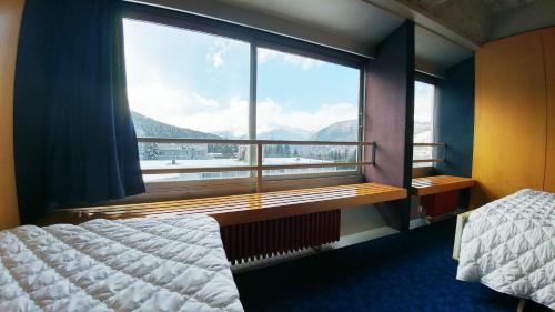 a bedroom with a large window with a view of mountains at Apartment Ski Marilleva 1400 in Marilleva