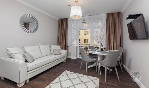 ein Wohnzimmer mit einem weißen Sofa und einem Tisch in der Unterkunft Apartamenty City. in Białystok