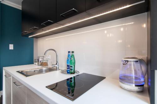 a kitchen with a sink and a counter top at Apartamenty City. in Białystok