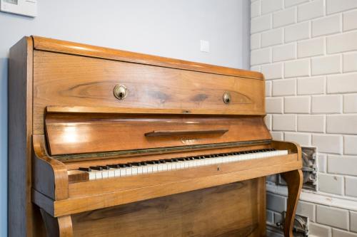 an old wooden piano sitting in a room at Apartamenty City. in Białystok