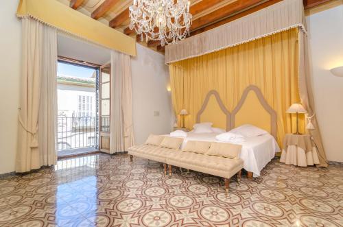 a bedroom with a large bed and a chandelier at Can Pati in Sóller