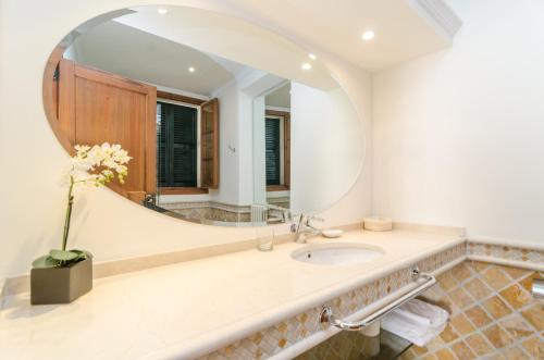 a bathroom with a large mirror and a sink at Can Pati in Sóller