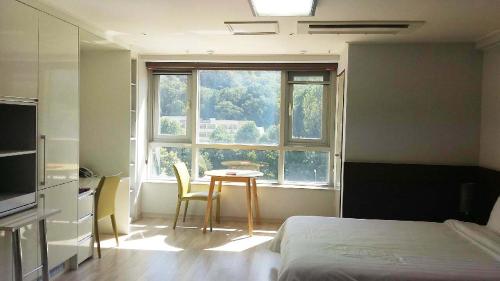 大田的住宿－高恩酒店，客房设有床、桌子和窗户。