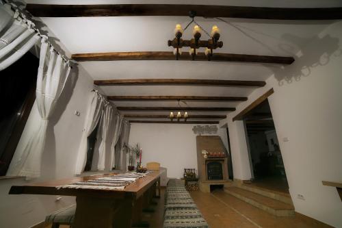 a room with a wooden table and a fireplace at Casa Verde in Voronet