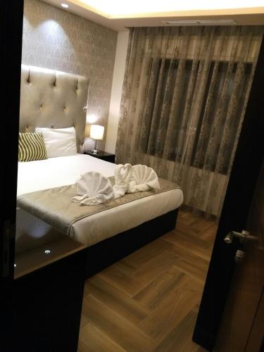 a bedroom with a bed with two towels on it at Nadine Hotel Suites in Amman