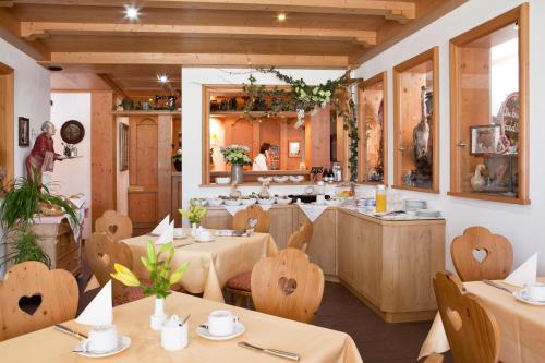 a restaurant with tables and chairs and a kitchen at Hotel Hubertus in Kissing