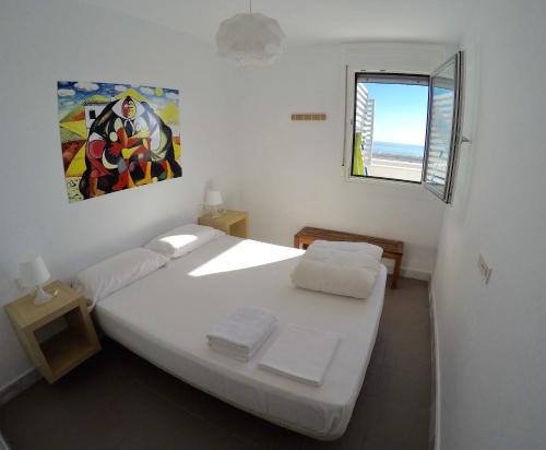 Una habitación blanca con una cama y una ventana en Cerro Mar, en El Cerro Blanco