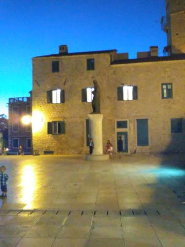 a large stone building with a statue in front of it at Apartment Vinko in Šibenik