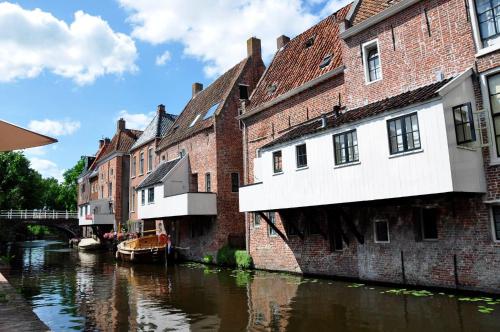 a group of buildings next to a river at Hotel-Appartementen Klaver Vier in Wagenborgen