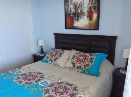 a bedroom with a bed with two pillows on it at Departamento 43D Condominio Cau Cau in Puchuncaví