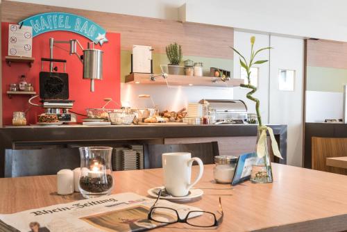 a table with glasses on top of a kitchen at ibis Koblenz City in Koblenz