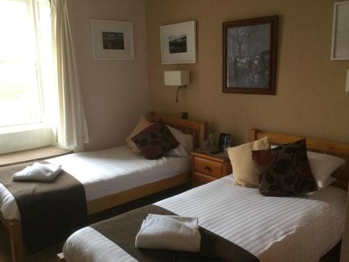 a hotel room with two beds and a window at The Golf Hotel in Crail