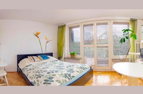 um quarto com uma cama, uma mesa e uma janela em Słoneczny apartament z balkonem em Gdansk