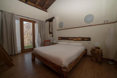 a bedroom with a bed and a large window at Agriturismo Il Mirtillo B,B in Pasturo