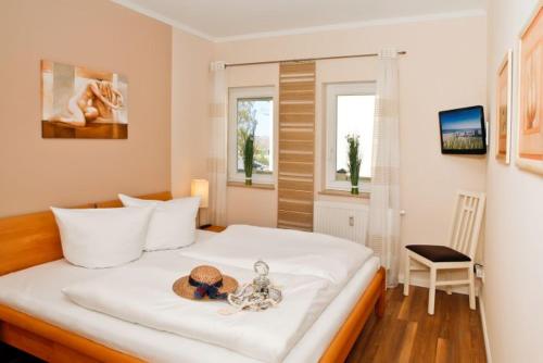 ein Schlafzimmer mit einem Bett mit Hut darauf in der Unterkunft Appartmenthaus Villa Laura in Kühlungsborn