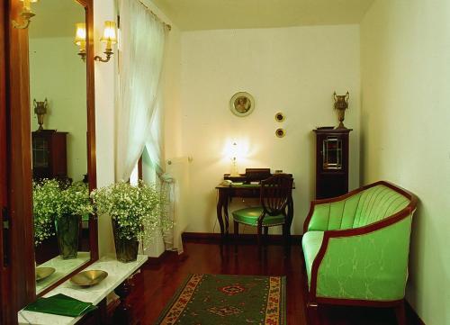 een woonkamer met een stoel en een tafel met een bureau bij Dworek Aleksandria in Ciechocinek