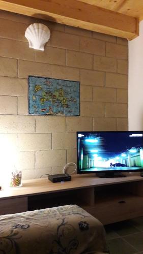 a desk with a television on a brick wall at La Casa di Titina in Procida