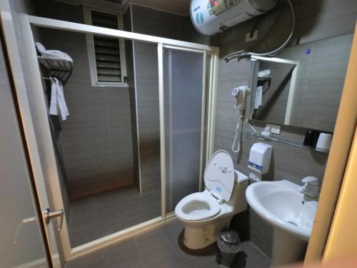 a bathroom with a shower and a toilet and a sink at Long Zhi Yue Hotel in Nangan