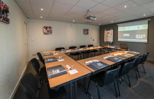 une salle de conférence avec une longue table et des chaises dans l'établissement Campanile Agen, à Agen